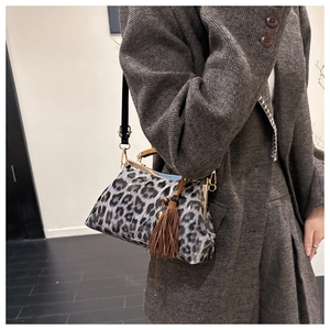 Détail du sac léopard avec fermoir en métal vintage et pompon marron décoratif