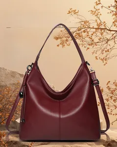Detail of burgundy large tote bag in lychee texture leather with heart pendant