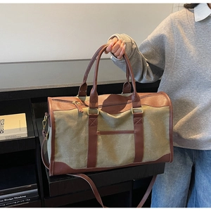 Close-up of olive green canvas tote bag with brown leather handles and adjustable strap