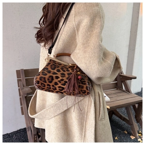 Sac docteur léopard chic avec fermoir métallique et pompon sur un manteau en tweed