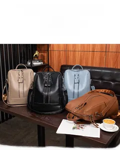 Close-up of four soft leather backpacks in khaki, black, blue, and brown with dual zippers