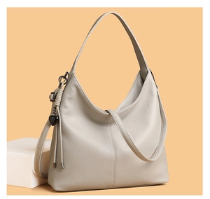 Detail of grey hobo bag showing pebbled leather texture and heart tassel charm
