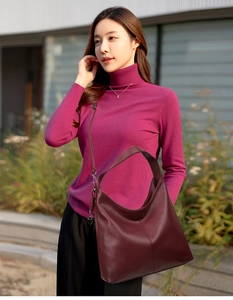 Detail of burgundy hobo bag with lychee texture and heart charm in a commute style