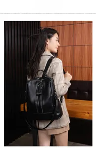 Detail of soft black faux leather backpack with double zippers and litchi texture