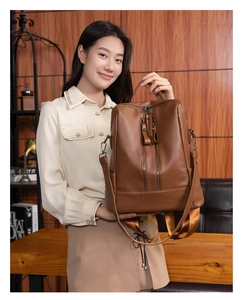 Deep brown pebble grain leather backpack with dual zippers shown in a lifestyle scene