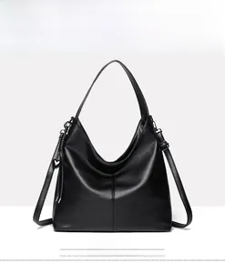 Close-up of black lychee grain tote bag featuring heart charm and vertical stitching details