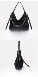 Detail view of large black pebble leather tote bag with a heart charm and dual strap options