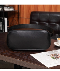 Detail of black lychee grain leather bag with adjustable wide woven shoulder strap