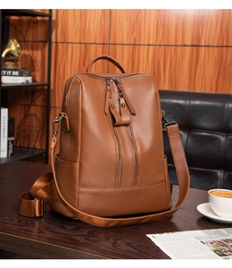 Close-up of brown litchi grain leather backpack with dual vertical zipper detail