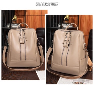 Detailed close-up of beige faux leather backpack with dual vertical zippers and side pockets