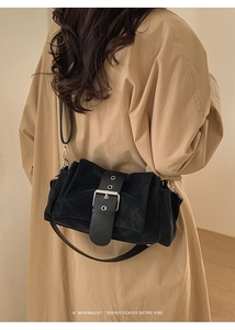 Détail du sac bandoulière rétro en daim avec grande boucle argentée sur trench-coat