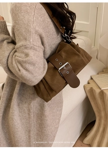 Détail du sac plissé marron avec boucle argentée sur un mannequin au style rétro chic