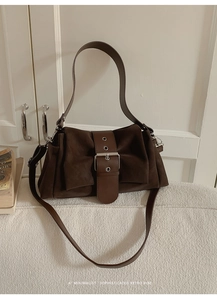 Détail du sac porté épaule rétro marron foncé avec boucle argentée et texture mate