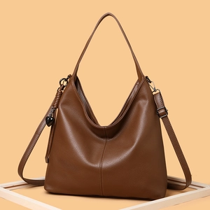 Brown large capacity tote bag with lychee texture and heart charm in studio setting