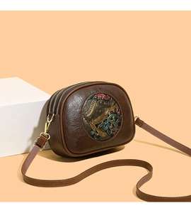 Detail of retro dark brown embossed leather bag with colorful elephant motif