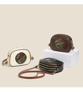 Detailed view of vintage embossed crossbody bags with triple zipper compartments