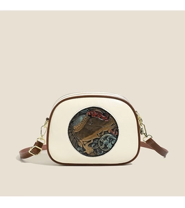 Detail showing the retro floral elephant embossed round relief on the beige leather bag