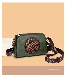 Detail of vintage green embossed crossbody bag with Chinese style pattern and wide strap