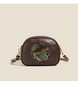 Close-up of vintage brown crossbody bag with colorful embossed ethnic elephant pattern