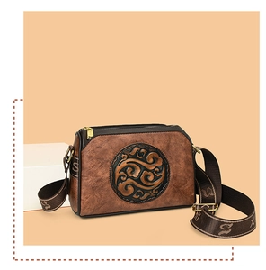 Close-up of vintage brown crossbody bag featuring intricate circular embossed pattern