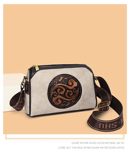 Detail of vintage embossed crossbody bag with wide logo strap and cloud pattern