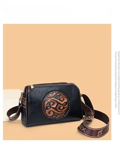Detail of vintage black crossbody bag with brown cloud embossment and jacquard strap