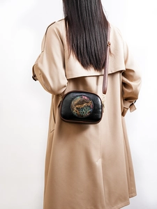 Ethnic shoulder bag with colorful elephant embossing and brown leather strap on model