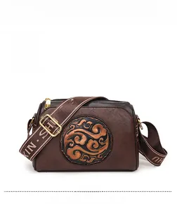 Macro detail of brown vintage embossed leather bag with golden zipper and strap