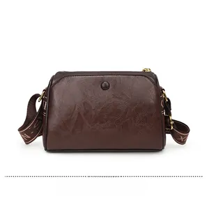 Detailed back view of vintage embossed dark brown leather crossbody bag with wide strap
