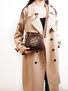 Detail of vintage embossed crossbody bag featuring elephant pattern on brown leather