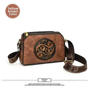 Detail of yellow brown retro embossed crossbody bag with cloud pattern and gold hardware