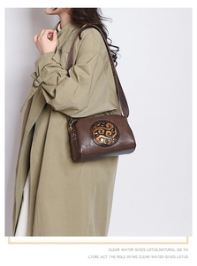 Detail of vintage embossed crossbody bag with retro floral carving on brown leather