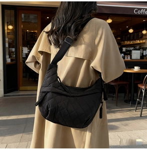 Detail of black quilted nylon half-moon bag with adjustable wide shoulder strap