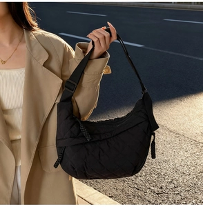 Close-up of black quilted nylon dumpling bag featuring an adjustable wide strap