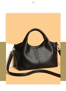 Detail of black lychee grain leather tote bag with wide strap and metallic hardware