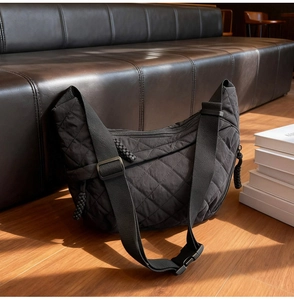 Close-up of black quilted hobo bag with adjustable strap and durable nylon texture