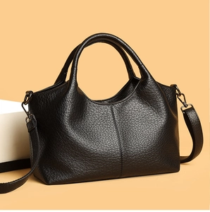Close-up of black leather handbag featuring premium lychee texture and dual round handles