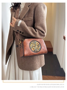 Close-up of vintage embossed leather crossbody bag with ethnic jacquard wide strap