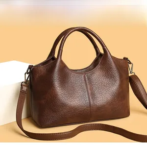 Detail of dark brown lychee pattern faux leather tote bag with sturdy handles