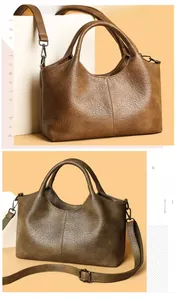 Close-up of litchi grain leather handbags in brown and olive with adjustable straps