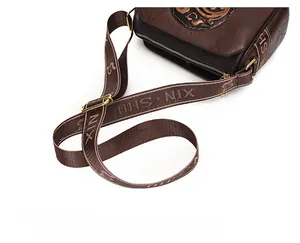 Close-up of vintage embossed bag with patterned wide strap and retro texture