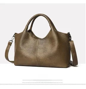 Detail of vintage olive green tote bag showing pebbled leather texture and metal buckles