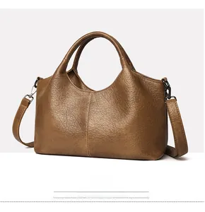 Detail view of brown pebbled leather texture and stitching on a large tote bag