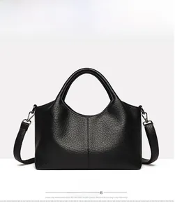 Detail view of black pebbled leather tote with detachable strap and curved top handle