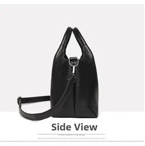 Detailed side view of black lychee leather bag with silver metal D-ring and strap