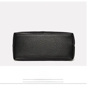 Close-up of bottom base on black pebble leather handbag showing neat stitching detail