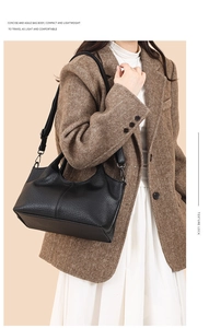 Detailed close-up of textured black leather bag showing refined litchi grain and soft handle