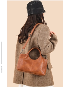 Brown lychee leather handbag detail showing adjustable strap and vintage buckle