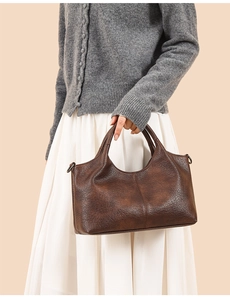 Detail of dark brown vintage texture tote bag with double handles and D-ring buckle