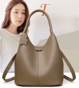 Dettaglio della borsa tote in pelle kaki con grana litchi e ciondolo a forma di orso